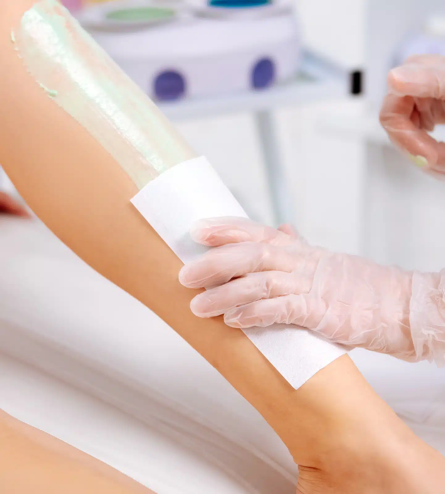 woman receiving leg waxing treatment